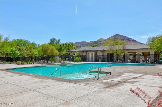 pool with a patio area, fence, and a mountain view