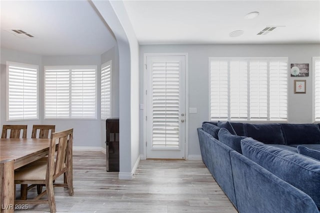 living area featuring baseboards, visible vents, and light wood-style floors