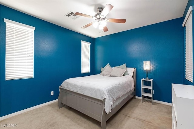 carpeted bedroom featuring a ceiling fan, visible vents, and baseboards