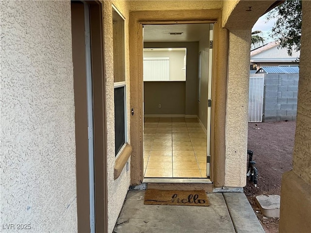 doorway to property featuring stucco siding