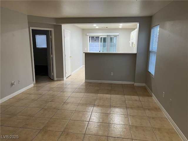 unfurnished room featuring light tile patterned flooring and baseboards