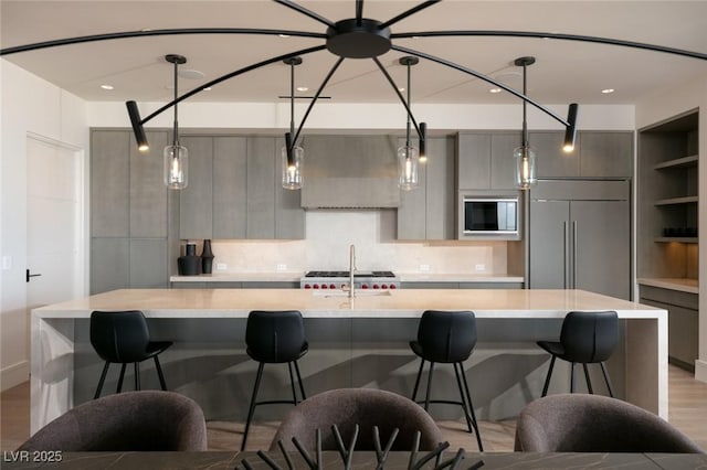 kitchen featuring modern cabinets, light countertops, and built in appliances