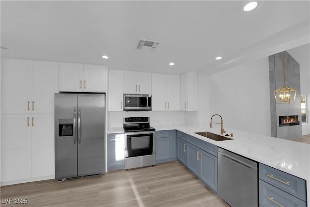 kitchen with white cabinets, visible vents, stainless steel appliances, and a sink