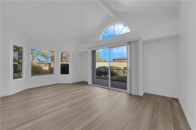 spare room featuring high vaulted ceiling, light wood-style floors, baseboards, and beamed ceiling