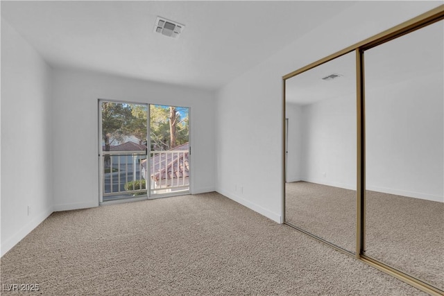 unfurnished bedroom featuring carpet floors, a closet, and visible vents