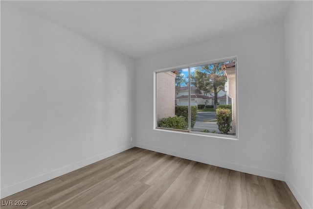 empty room with light wood-type flooring and baseboards