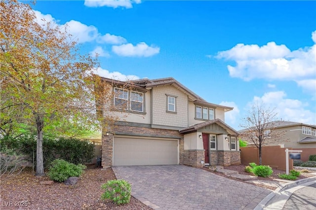 craftsman-style house featuring a garage, stone siding, fence, decorative driveway, and stucco siding