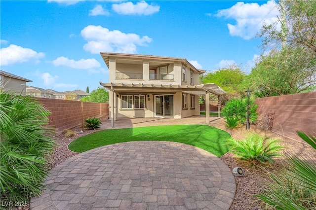 back of house with a patio, a fenced backyard, a balcony, and stucco siding