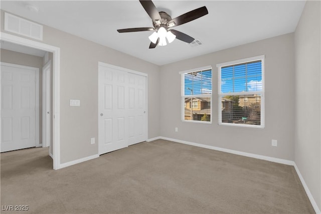 unfurnished bedroom featuring a closet, carpet, visible vents, and baseboards