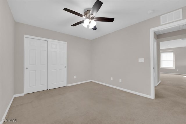 unfurnished bedroom featuring carpet floors, a closet, visible vents, and baseboards