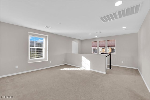 spare room featuring baseboards, visible vents, light colored carpet, and recessed lighting