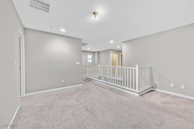 carpeted spare room featuring recessed lighting, visible vents, and baseboards