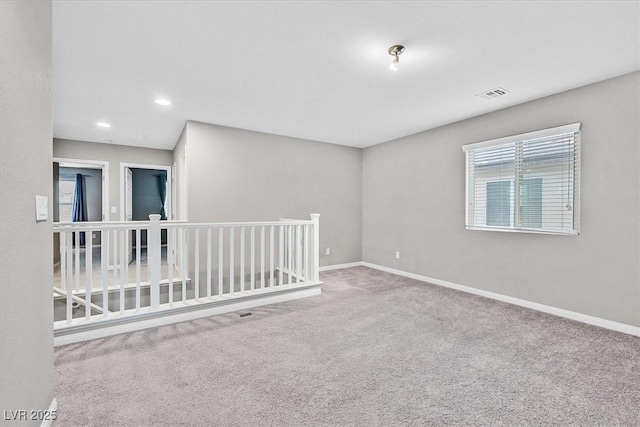 carpeted empty room featuring recessed lighting, visible vents, and baseboards