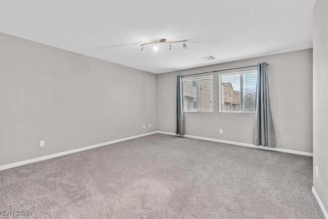 empty room featuring visible vents, baseboards, and carpet flooring