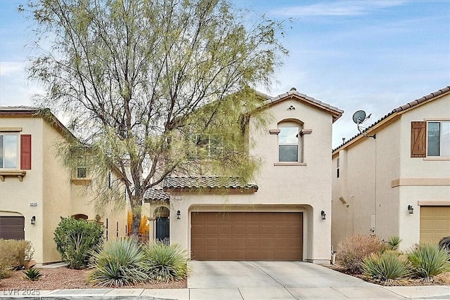 mediterranean / spanish-style home with driveway, a tiled roof, an attached garage, and stucco siding