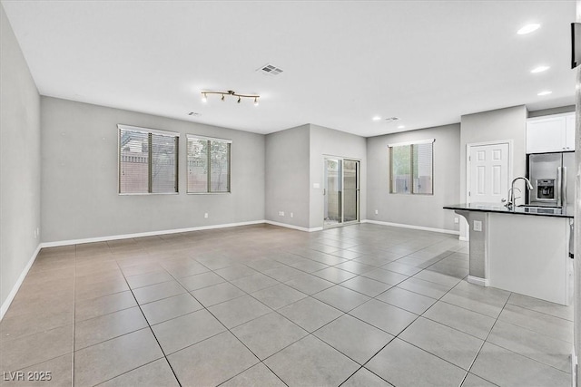 unfurnished living room with light tile patterned floors, baseboards, visible vents, and recessed lighting