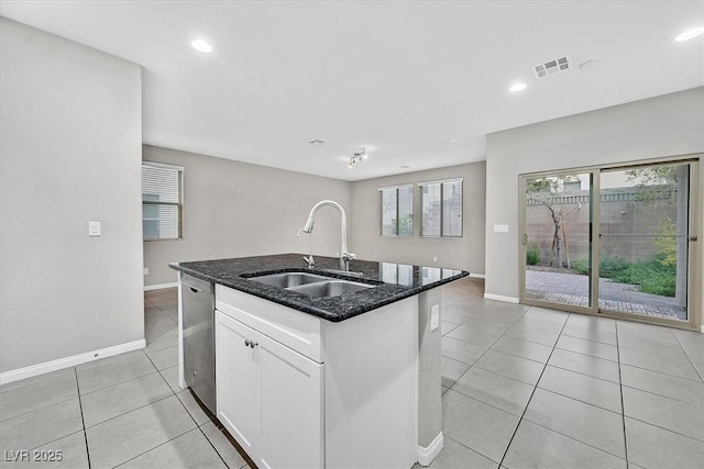 kitchen with light tile patterned floors, visible vents, a sink, dark stone counters, and dishwasher