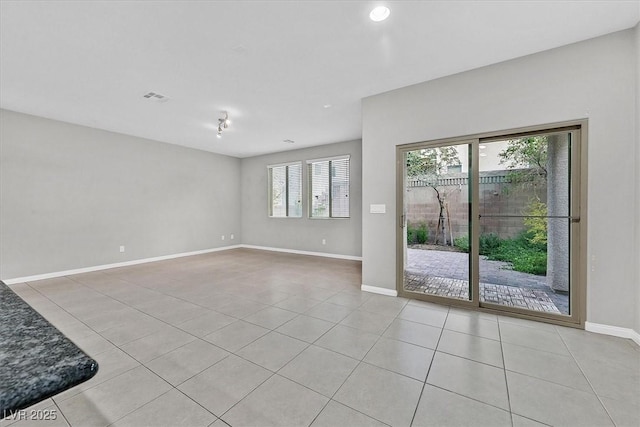 empty room featuring visible vents, baseboards, and light tile patterned floors