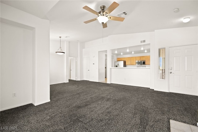 unfurnished living room with visible vents, vaulted ceiling, a ceiling fan, and light colored carpet