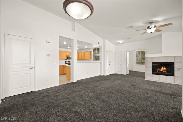 unfurnished living room with light carpet, vaulted ceiling, visible vents, and a fireplace