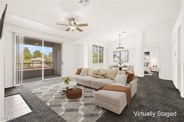 living area featuring plenty of natural light, visible vents, and carpet flooring