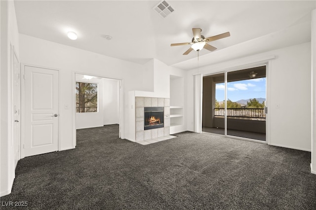 unfurnished living room featuring carpet floors, visible vents, a fireplace, and ceiling fan