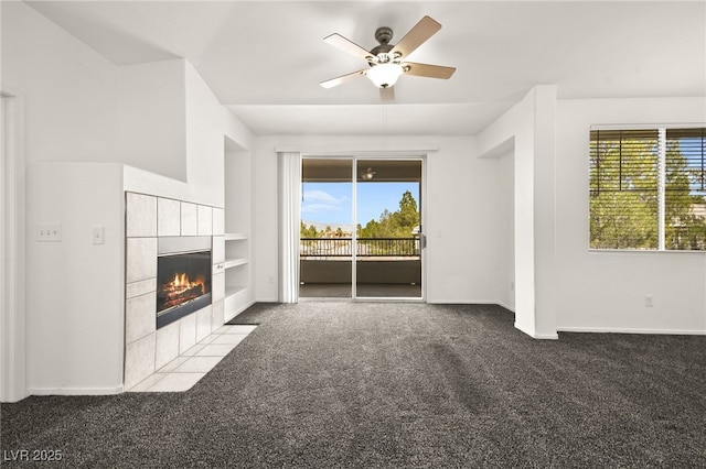 unfurnished living room featuring built in features, carpet, ceiling fan, a tile fireplace, and baseboards