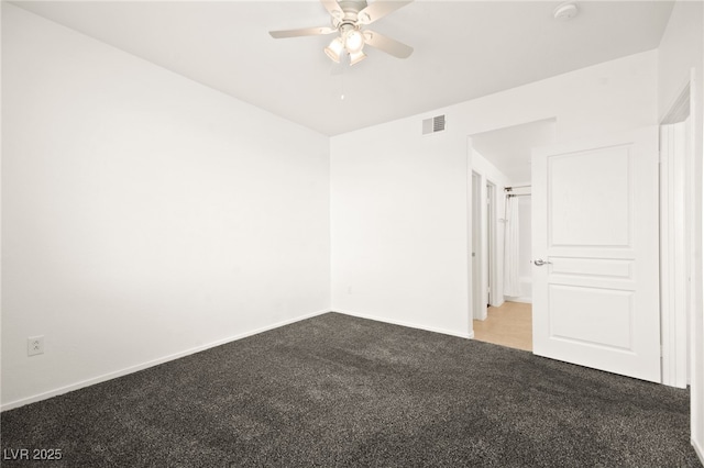 empty room featuring carpet floors, visible vents, baseboards, and a ceiling fan