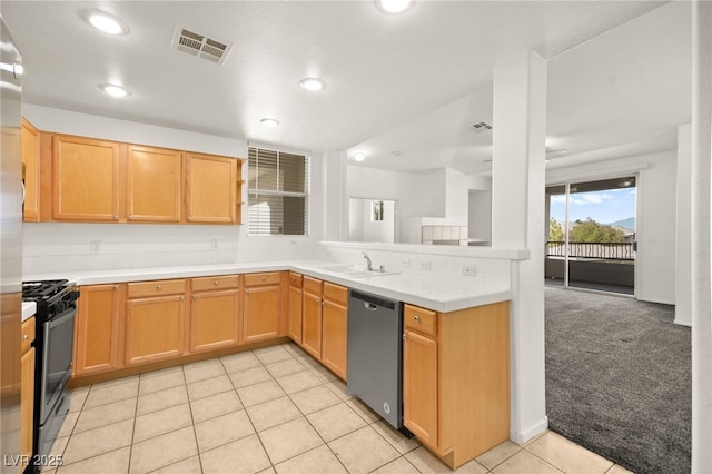 kitchen with light colored carpet, a peninsula, a sink, visible vents, and appliances with stainless steel finishes