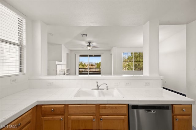 kitchen with light countertops, visible vents, stainless steel dishwasher, a ceiling fan, and a sink