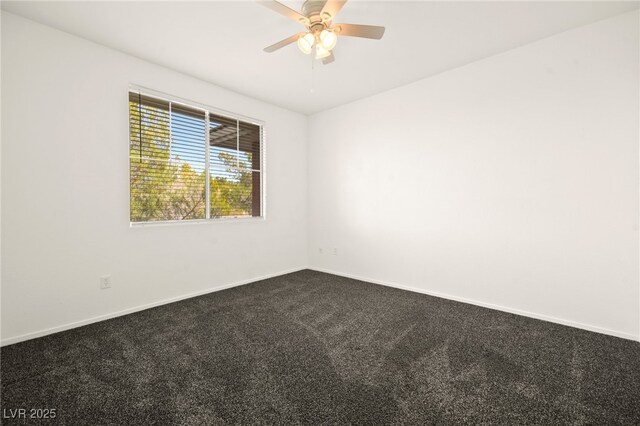 empty room featuring dark carpet, a ceiling fan, and baseboards