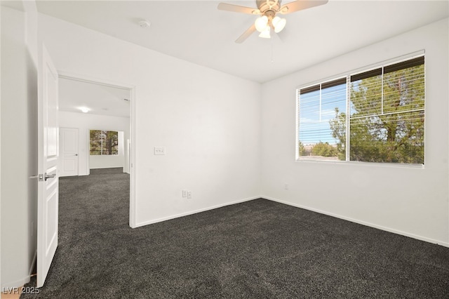 spare room with ceiling fan, baseboards, and dark colored carpet