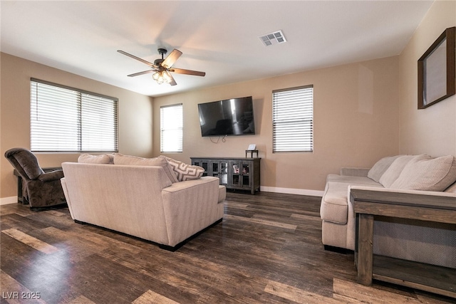 living area featuring visible vents, dark wood finished floors, baseboards, and ceiling fan