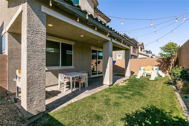 view of yard featuring fence private yard, a patio area, and a playground