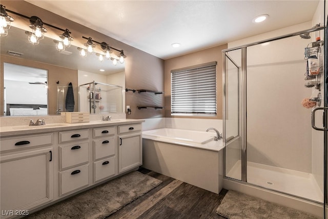 bathroom featuring double vanity, a stall shower, a sink, and visible vents