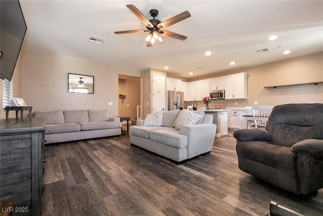 living room featuring dark wood-type flooring, recessed lighting, visible vents, and a ceiling fan