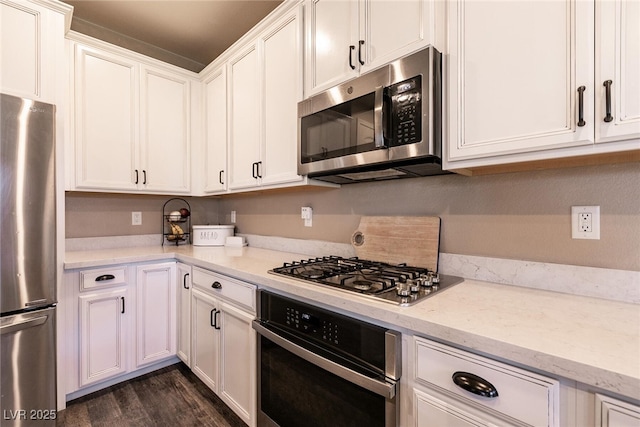 kitchen featuring dark wood-style floors, appliances with stainless steel finishes, and white cabinets