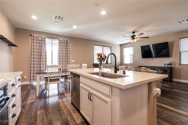 kitchen featuring dark wood-type flooring, visible vents, dishwasher, and a sink