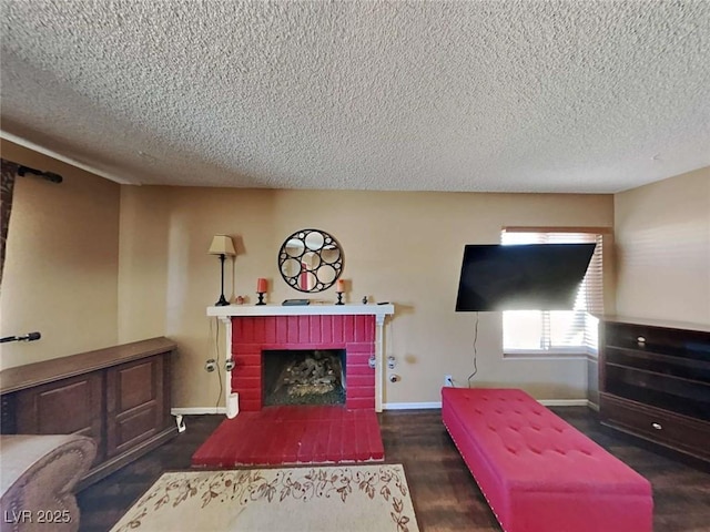 living room with a brick fireplace, a textured ceiling, baseboards, and wood finished floors