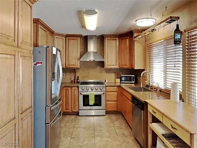 kitchen featuring light tile patterned floors, tasteful backsplash, wall chimney exhaust hood, stainless steel appliances, and a sink