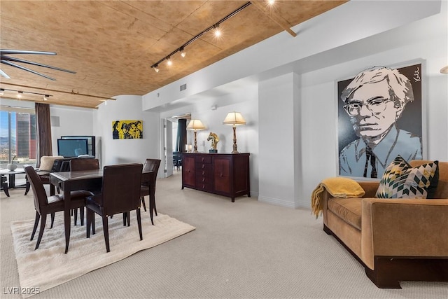 dining room with rail lighting and carpet