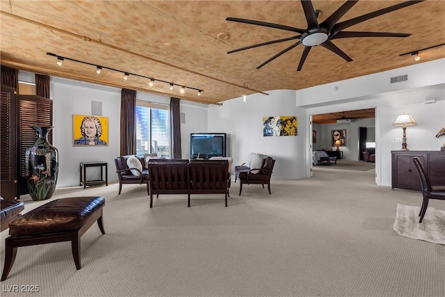 living area with carpet floors, visible vents, ceiling fan, and track lighting