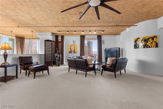 sitting room with ceiling fan, carpet, rail lighting, and a wealth of natural light