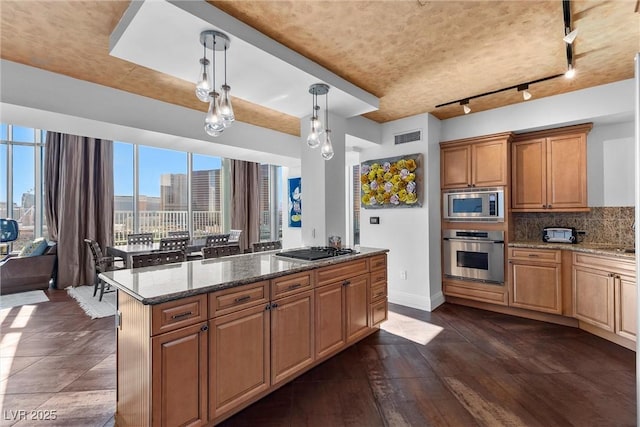 kitchen featuring tasteful backsplash, visible vents, appliances with stainless steel finishes, dark wood-type flooring, and dark stone counters