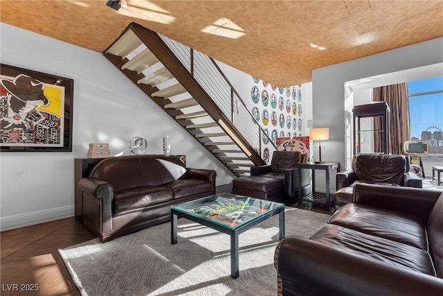 living area featuring stairway and baseboards