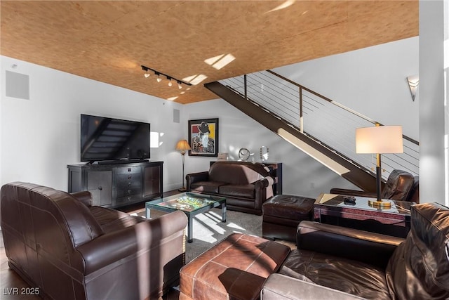 living area featuring stairway and rail lighting