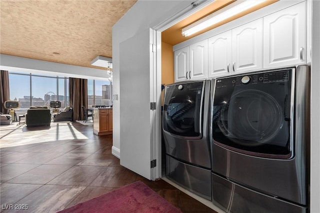 laundry area with cabinet space, a city view, and independent washer and dryer