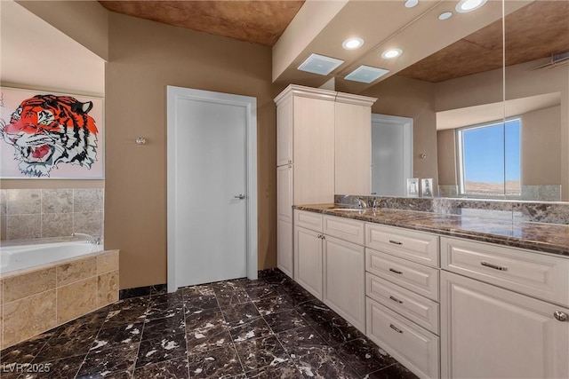 full bathroom with tiled bath, visible vents, and vanity