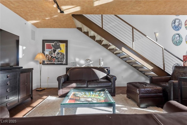 living room featuring visible vents, baseboards, and stairs