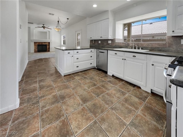 kitchen featuring dark countertops, tasteful backsplash, appliances with stainless steel finishes, and a sink